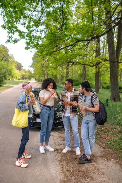 Tourists. Group of young people standing in the forest near the car