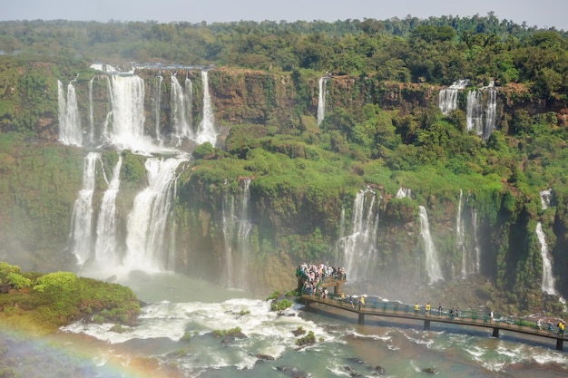 Tourists on platform in waters of iguacu river at iguacu falls brazil