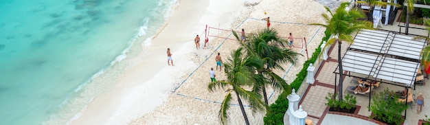Turisti che giocano a pallavolo sulla spiaggia in hotel di lusso a cancun messico