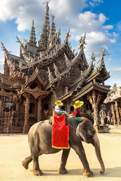 Tourists ride elephant around the Sanctuary of Truth in Pattaya in Thailand