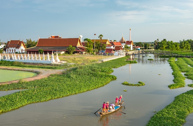 Tourists ride wooden boat in the canal and the temple.