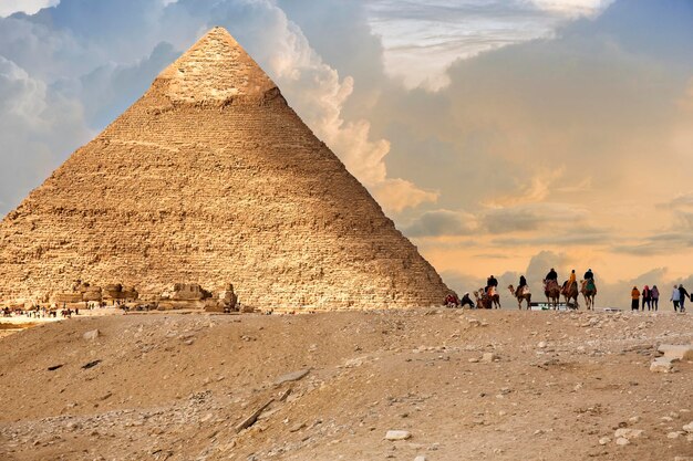 Photo tourists riding horses and camels near the pyramid of cheops