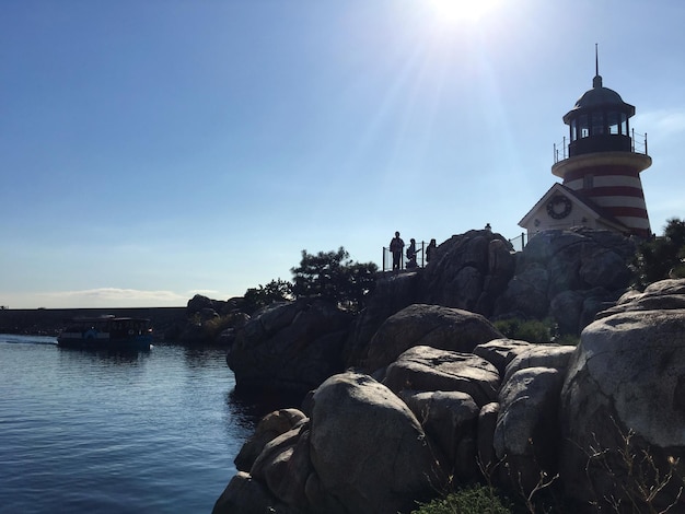 Tourists on rock against sky