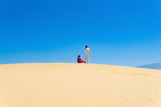 Tourists on the slope of the Sarykum sand dune in Dagestan