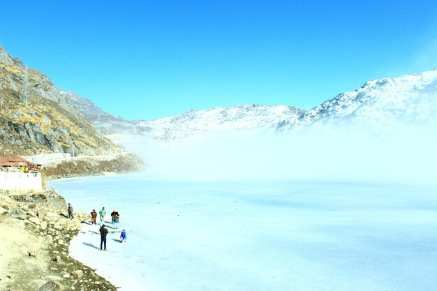 Tourists on snow covered mountain