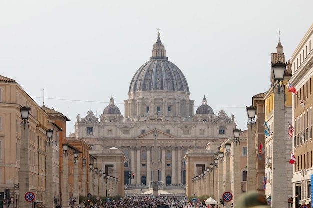 Tourists on the St. Peter's Square, architectural masterpiece with Michelangelo's dome in Vatican.