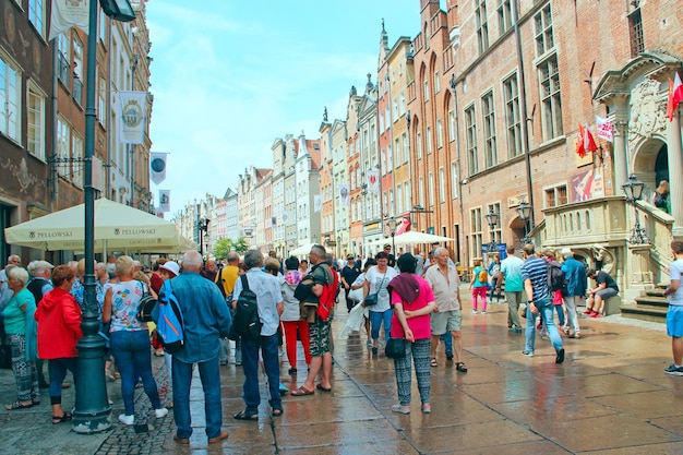 Tourists stroll on Gdansk during rain Many tourists walk around Gdansk Beautiful tourist