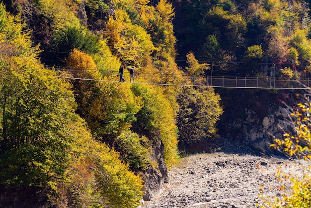 Tourists on the suspension bridge over the river