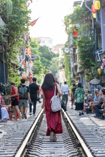 Tourists taking pictures of hurtling train The Hanoi Train Street is a popular attractionView of train passing through a narrow street of the Hanoi Old Quarter