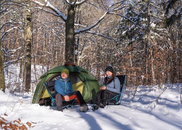 Tourists at the tent in the snowy forest