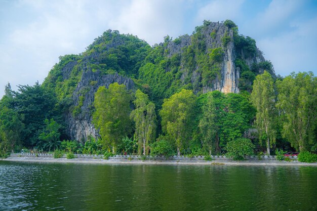 Foto turisti che viaggiano in barca lungo il fiume ngo dong nella porzione di tam coc della provincia di ninh binh, vietnam.