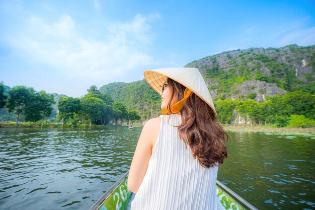 写真 ベトナムのニンビン省のタンコク川沿いのボートで旅行する観光客 ローヤーが足で漕ぎを推す カルストの塔と米畑で形成された景色