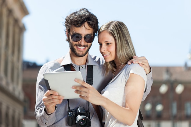 Tourists using a digital tablet in a city