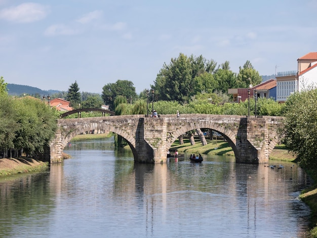 Tourists walking along the Roman stone bridge over the river Cabe