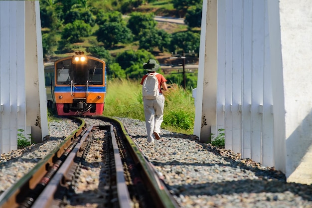 Tourists walking along the train tracks Waiting to take pictures of the passing train