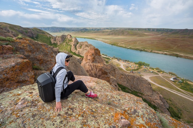 Tourists with backpacks relaxing on rocks