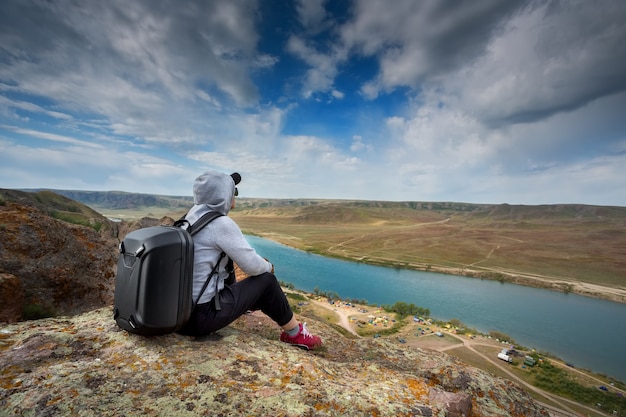 Tourists with backpacks relaxing on rocks