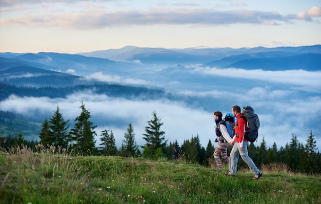 Tourists with backpacks walking along mountain path