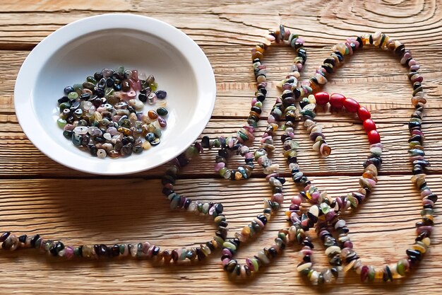 Tourmaline beads on wooden background Necklace beads from tourmaline mineral stone