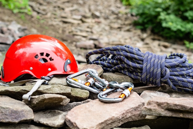 Touwtoegangsgereedschap: helm, touw, karabijnhaak. Bergsportuitrusting op rotsen