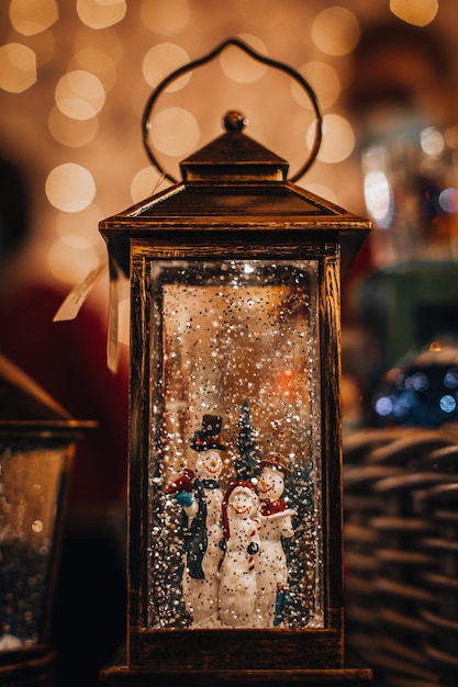 Foto toverlantaarn feestelijke wintercompositie met sneeuwmannen familie nieuwjaarsinstallatie voor kerstmis