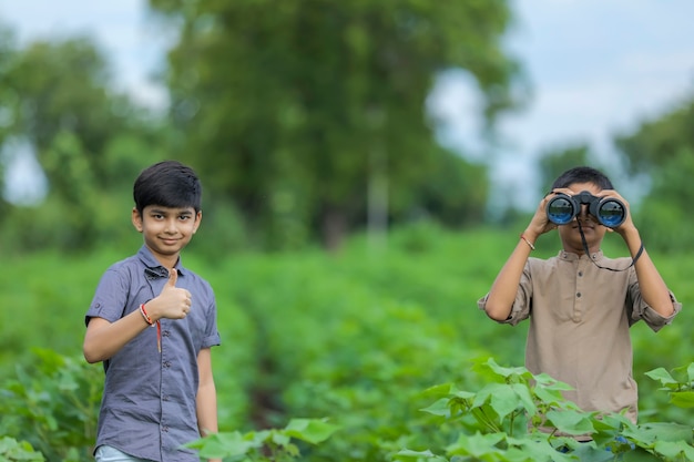 双眼鏡で自然の中で楽しんでいるインドの少年をけん引