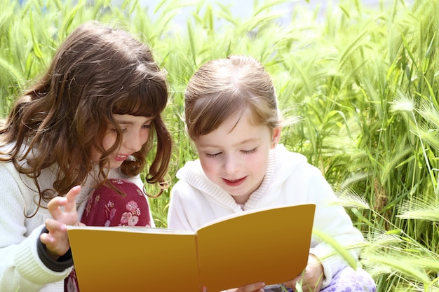 Tow little sister girls lezen boek spikes tuin