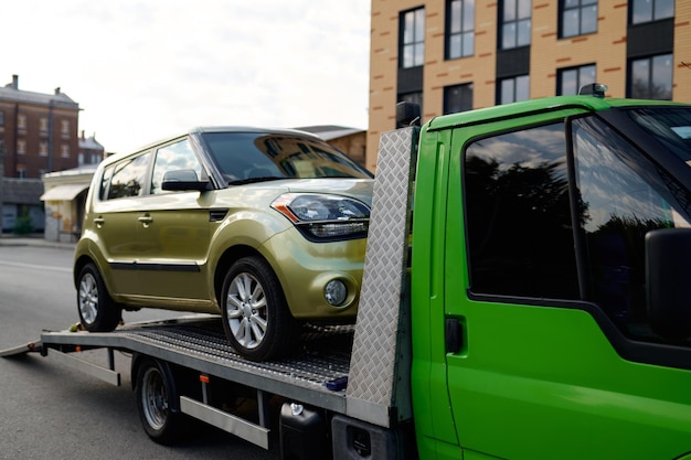 Tow track vehicle taking away broken faulty car down street. Automotive emergency service concept