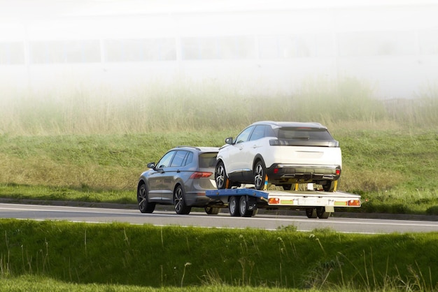 Tow truck delivering broken car on highway