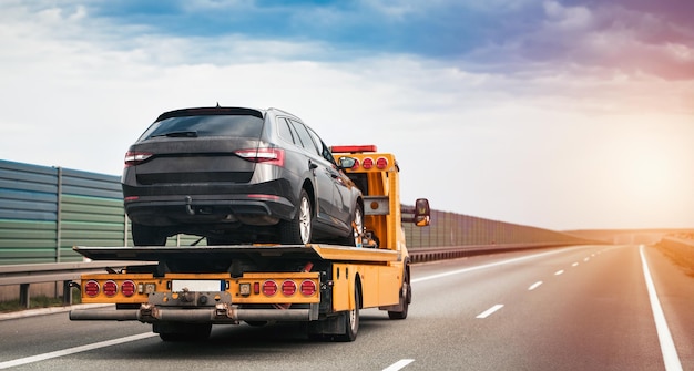 Photo a tow truck on the public road tow truck with broken car on country road tow truck transporting car on the highway car service transportation concept