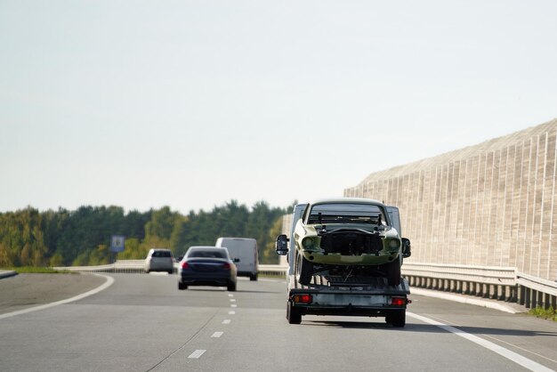 A tow truck with a broken car on a road Tow truck transporting a car on the highway Car service transportation concept Roadside Rescue