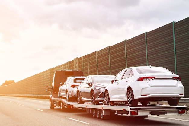 Photo tow truck with a cars on the highway road tow truck transporting car on the autobahn car service transportation concept roadside rescue