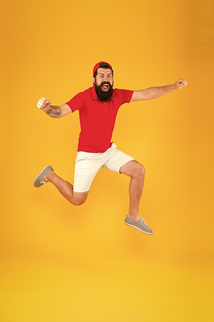 Towards fun enjoying active lifestyle happy guy jumping active bearded man in motion yellow background active and energetic hipster energy charge healthy guy feeling good inspired concept