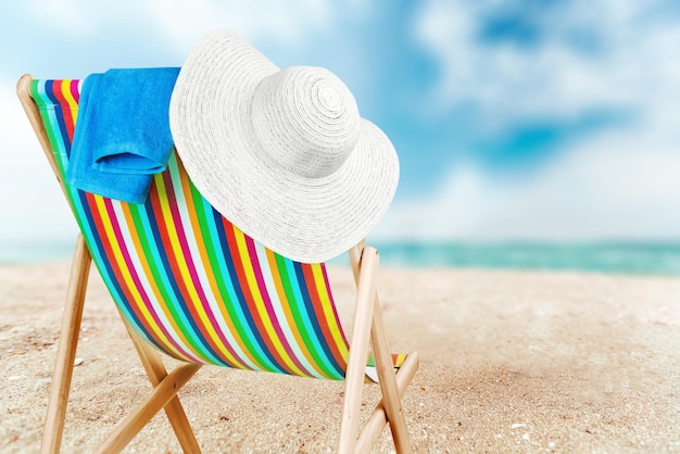 Towel and hat on a sun lounger with stripes,