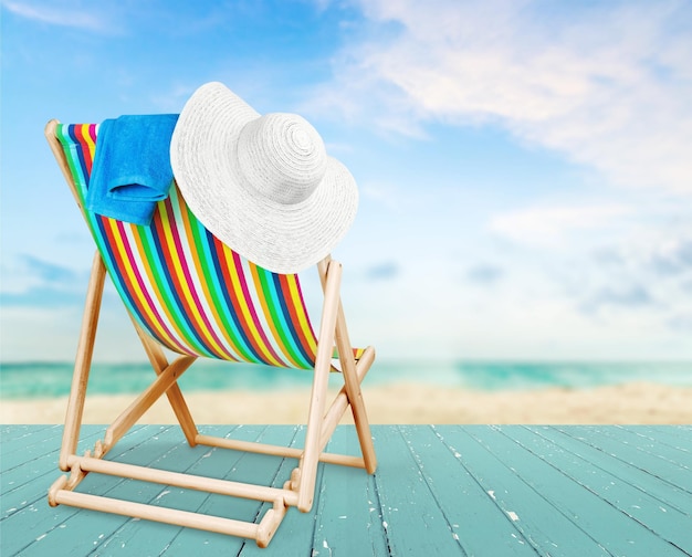 Towel and hat on a sun lounger with stripes,