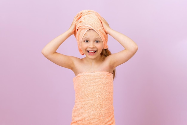 A towel on the head of a little girl taking a shower taking care of the body and hygiene