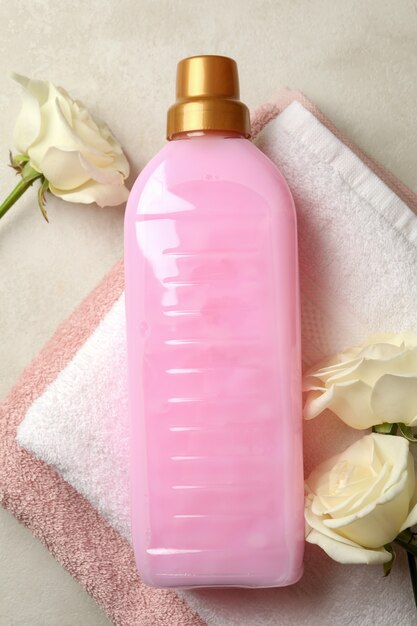 Towel, laundry liquid and roses on light beige textured