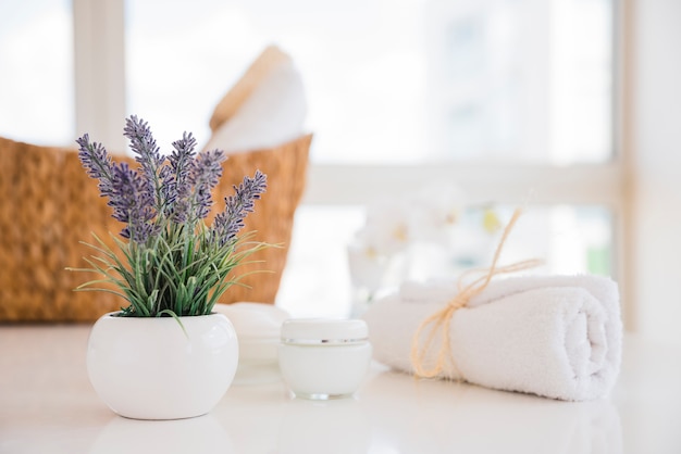Towel and lavender flowers on white table with cream
