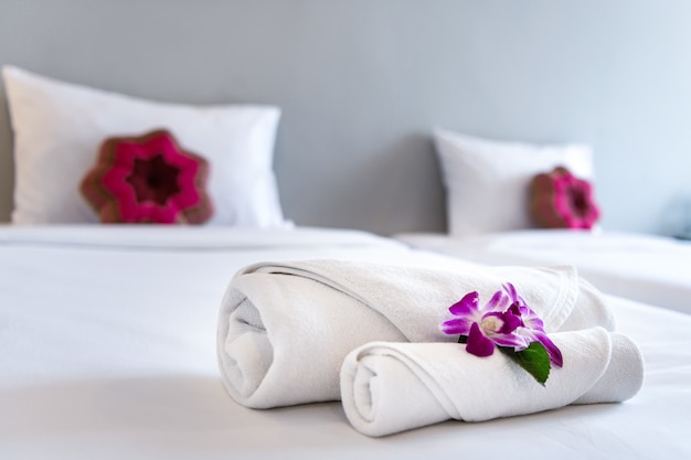 Photo towel with orchid on bed decoration in bedroom interior for hotel customer.