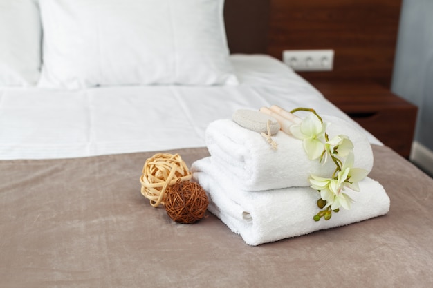 Photo towels and flower on bed in hotel room