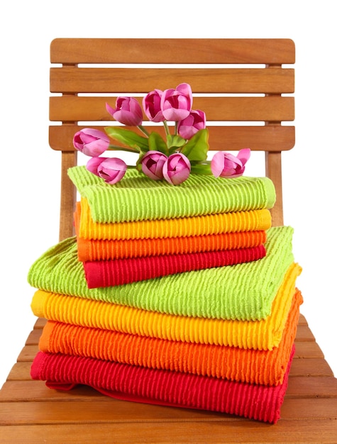 Towels and flowers on wooden chair isolated on white