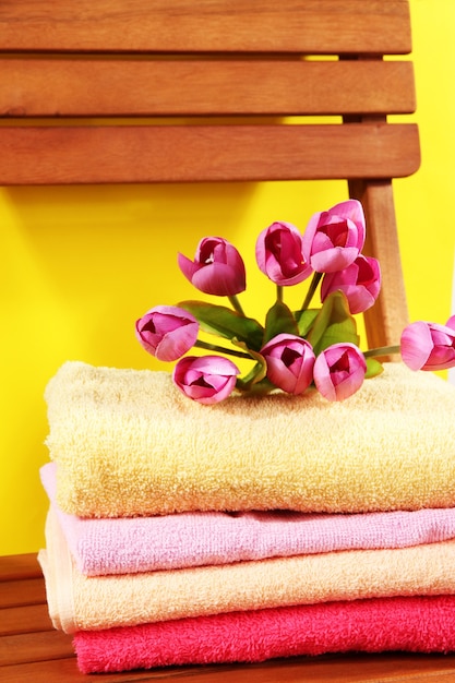 Towels and flowers on wooden chair