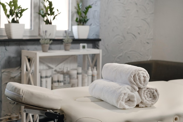 Towels on massage table in empty beauty salon