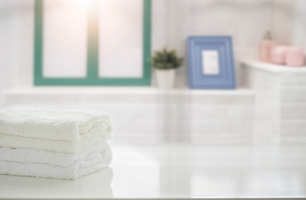 Towels on white table in bathroom with copy space.