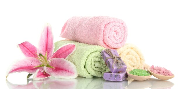 Towels with beautiful pink lily, aroma oil and sea salt isolated on white