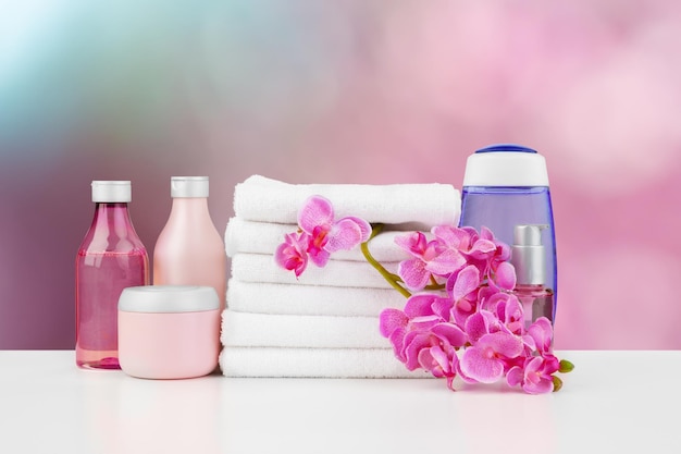 Towels with flowers on light table against blurred background