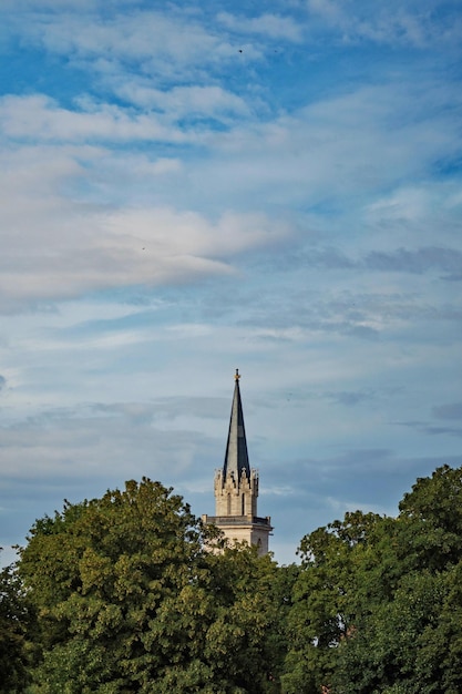 Tower amidst trees and building against sky