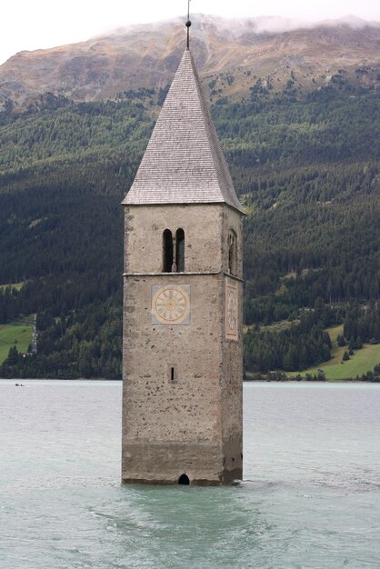 Photo tower amidst trees and buildings against sky