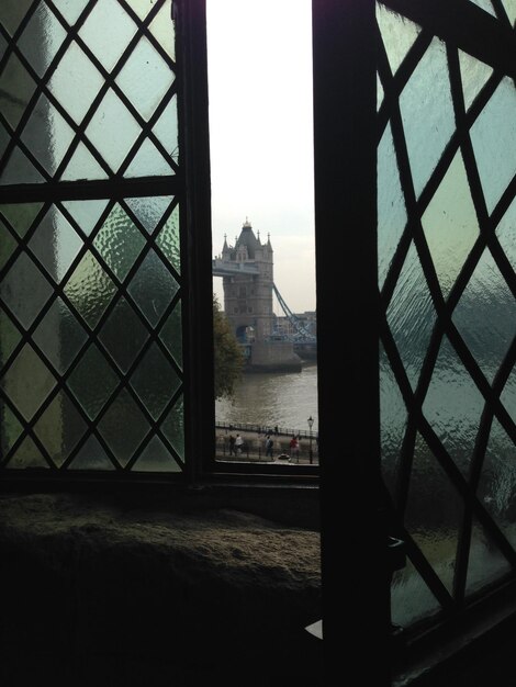 Foto il ponte della torre sul fiume visto da una finestra di vetro aperta