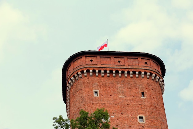 Photo tower of castle wawel in krakow in poland anf the national flag